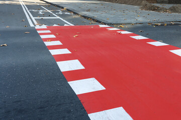 Bicycle lane painted red on crossroad outdoors