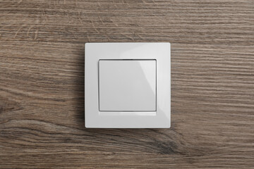 White plastic light switch on wooden background