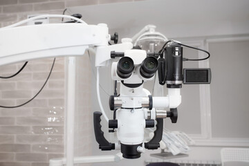 Dental microscope with video camera. against the background of modern dentistry. Medical equipment. operating microscope. with swivel double binoculars. dental microscope. an office in a white office