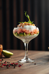 Salmon poke bowl with cheese and avocado in cocktail glass