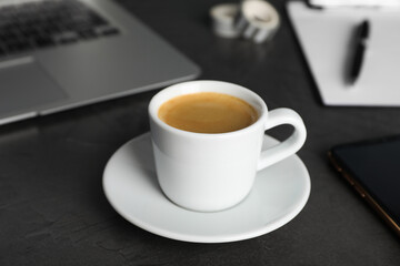 Fototapeta na wymiar Coffee Break at workplace. Cup of hot espresso on grey table