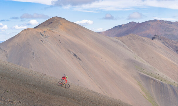 Man Riding Bicycle On Mountain Against Sky