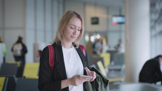 An attractive young woman at the airport is waiting for her departure. Documents