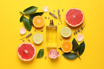 Selbstklebende Fototapeten Flat lay composition with bottle of perfume and fresh citrus fruits on yellow background © New Africa
