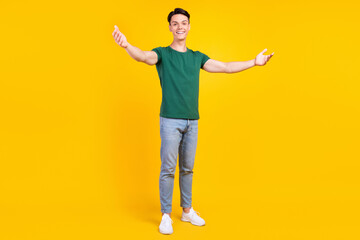 Fototapeta na wymiar Full size photo of cheerful charming positive man hold hands open smile enjoy isolated on yellow color background