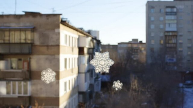 Hand pasting hand-made snowflake stickers on the window of a house, close-up, Full HD 1920 x 1080p. Snowflake pattern on window glass. Christmas home decoration concept.