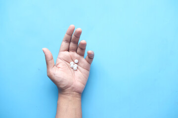 man's hand with medicine spilled out of the pill container 