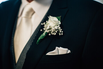 Close up stylish groom suit outfit with flower tuxedo and napkin on side. Groom accessories and...