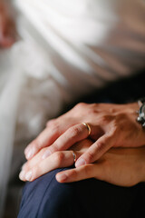 Close up detail of female and male hands of newlyweds at weddings displaying gold wedding rings