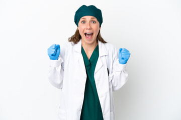 Surgeon caucasian woman in green uniform isolated on white background celebrating a victory in winner position