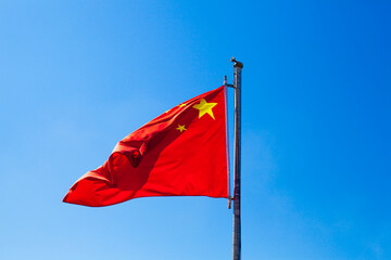 National Flag of the People's Republic of China , Five-star Red Flag,  waving on the wind, blue sky in background.