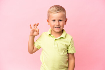 Little Russian boy isolated on pink background showing ok sign with fingers