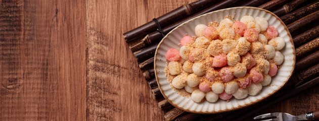 Deep-fried red and white tangyuan with peanut powder.