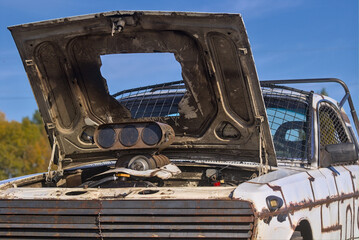 Kyiv Ukraine - A unique passenger car is made in a single copy. A pickup truck with a raised hood stands off-road outside the city. Sunny autumn day. Bright blue sky.