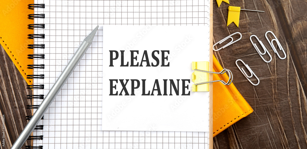 Poster please explain text on a sticker on the notebook, wooden background