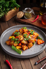 Asian cooked zander fish in sweet and sour sauce on wooden background