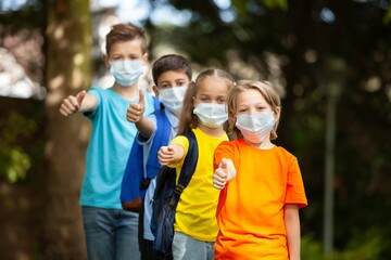children wearing  face medical mask back to school after covid-19 quarantine concept