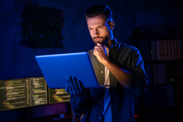 Photo of minded pensive guy arm on chin serious face look netbook project start-up late evening...