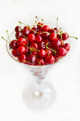 glass bowl of sweet cherry fruits isolated on white background