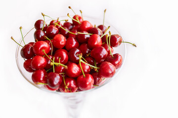 Naklejka na ściany i meble glass bowl of sweet cherry fruits isolated on white background
