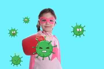 Cute little girl wearing superhero costume and boxing gloves fighting against viruses on turquoise...