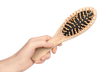 Wooden hairbrush in a female hand on a white background, isolate