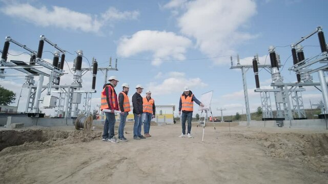 Engineers supervise the construction of a transformer substation