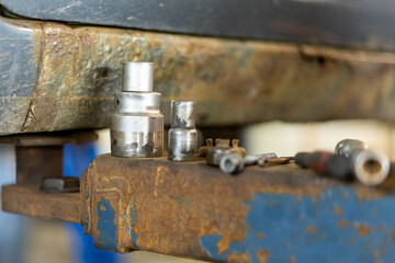 Close-up photo of parts for the car repair on rusty metal