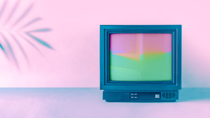 Minimal abstract vaporwave composition with shadow of tropical palm leaf and retro vintage television box. Pink and blue lights. Retro futuristic note card idea. Cyberwave background with copy space.