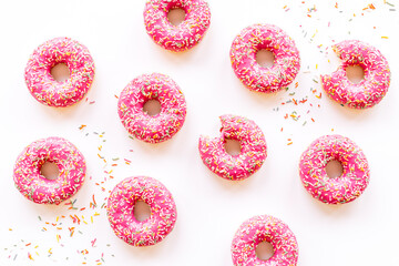 Bakery background of pink glazed donutes with sprinkles