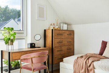 Modern teenage room interior design with bed, table, chest of drawers, pink velvet chair and...