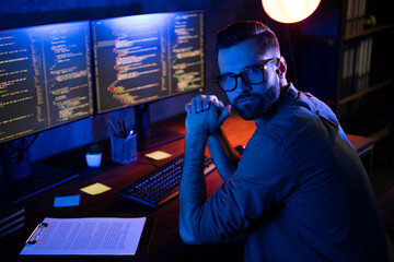 Photo of serious professional programmer look camera improving debugging service experience dark...