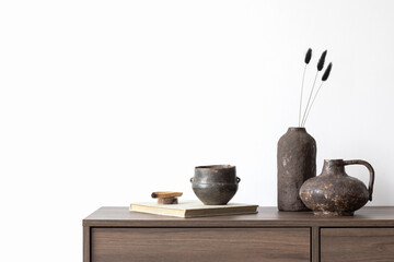Stylish living room interior composition with brown wooden commode, candle and small home...