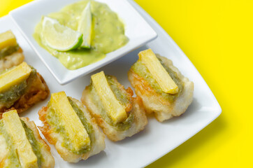Skinless and boneless battered Alaska Pollock fillet pieces, topped with mushy peas and fried potato