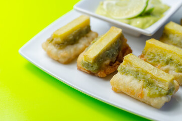Skinless and boneless battered Alaska Pollock fillet pieces, topped with mushy peas and fried potato