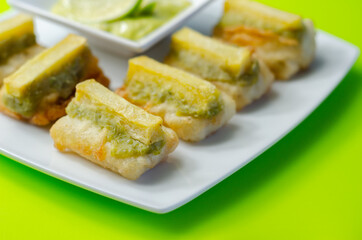 Skinless and boneless battered Alaska Pollock fillet pieces, topped with mushy peas and fried potato