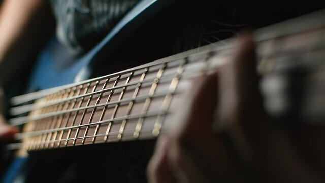 Bassplayer plays with his fingers on the modern 5 string bass in slow motion, 1080p 240fps