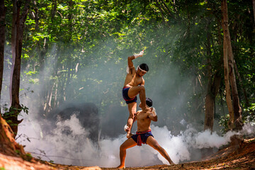 Fototapeta premium Thai boxers practicing boxing in a forest with elephants