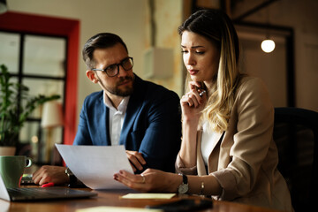 Colleagues in office. Businesswoman and businessman discussing work in office. Two friends working together.