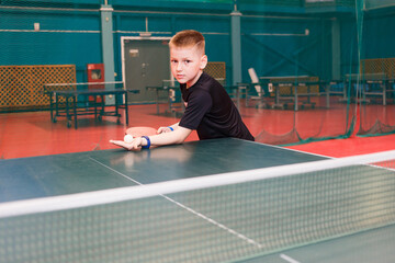 child gives a ball in table tennis. children and sports