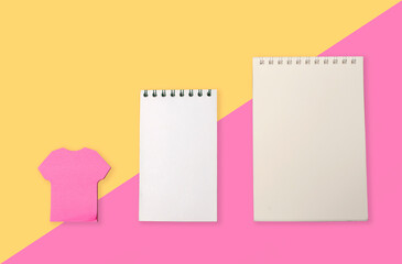 Notebook and pink sticker  isolated on yellow-pink background.Copy space