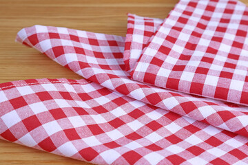 Fototapeta na wymiar Red and white checkers kitchen towel on wooden table
