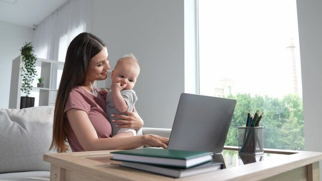 Manager ceo lady sit sofa use netbook maternity leave hold baby indoors