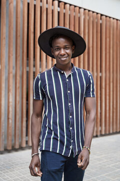 Portrait of hipster young African man with trendy casual wear and hat