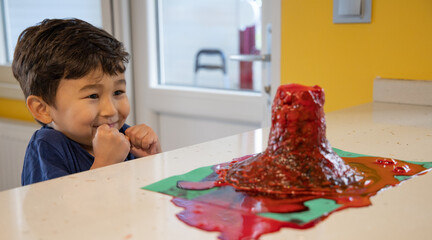 Exciting cute boy experimenting with volcano eruption
