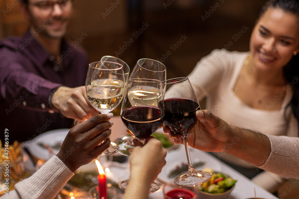 Wall mural holidays, party and celebration concept - multiethnic group of happy friends having christmas dinner