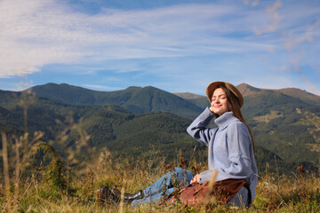 Young woman enjoying beautiful mountain landscape on sunny day