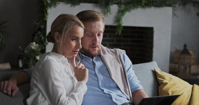 Male and female talking discussing buying house apartment choosing browsing online use laptop pc at home. Family enjoying partnership leisure internet entertainment shopping together order delivery