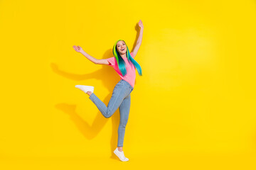 Fototapeta na wymiar Photo of cheerful positive young bright lady dressed pink t-shirt dancing empty space smiling isolated yellow color background