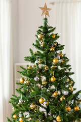 winter holidays, new year and celebration concept - green artificial christmas tree decorated with toys at home